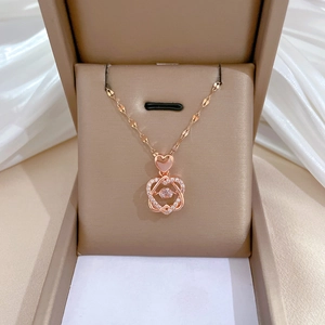 Detail of rose gold heart pendant with dancing stone in a beige jewelry box