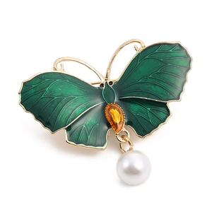 Elegant gold butterfly brooch with green enamel wings, yellow gemstone, and pearl pendant