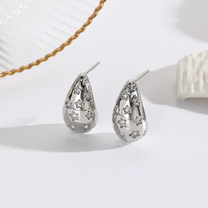 Macro shot of silver teardrop earrings with sparkling star-shaped rhinestones inlay