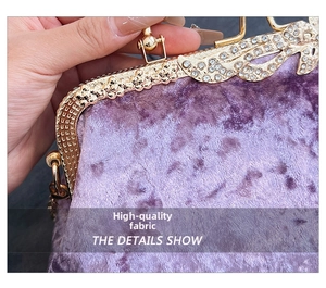 Close-up of purple velvet evening bag with gold floral metal frame and inlaid crystals
