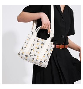 Dettaglio della borsa tote in velluto bianco con stampa di tulipani su modella