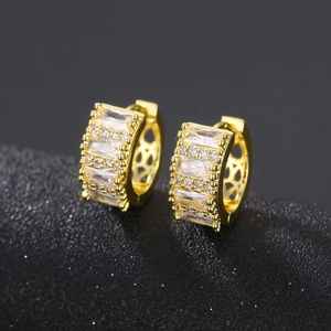 Gold huggie earrings featuring baguette-cut cubic zirconia in a minimalist geometric design