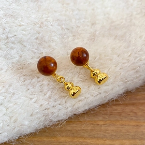 Gros plan détaillé de boucles d'oreilles gourde rétro avec perles en marbre ambré