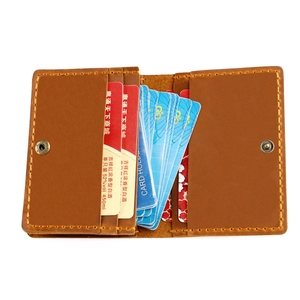 Detail of vintage crazy horse leather card holder with hand-stitched seams and metal snap