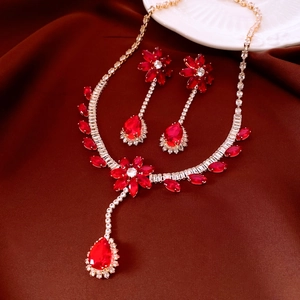 Detailed view of luxury gold necklace and earring set with red flower zircons