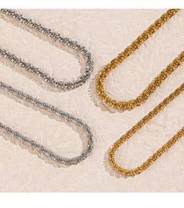 Detailed view of shimmering stainless steel necklaces in silver and gold finishes