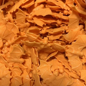 Close-up of bulk 4cm orange plastic bats for Halloween party decor and DIY crafts