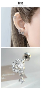 Macro shot of a heart-shaped zircon ear stud with a dangling round diamond charm