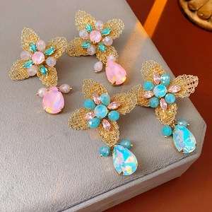 Detail of vintage floral earrings with rhinestones and teardrop crystals in pink and blue