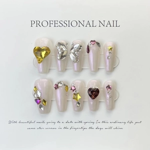 Macro view of long stiletto press-on nails with 3D hearts, pearls and silver charms