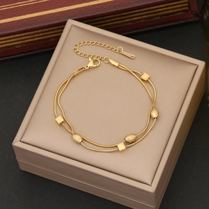 Golden double-layered stainless steel bead bracelet with lobster clasp on jewelry box
