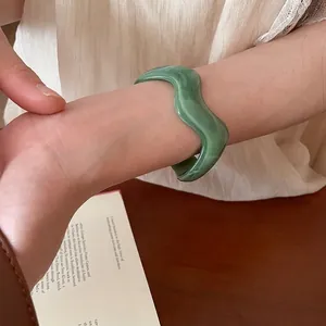 Irregular green wave acrylic open bangle with marble texture for a chic minimalist look