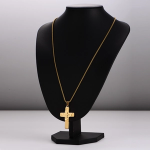Polished gold stainless steel cross necklace with geometric patterns on a black bust