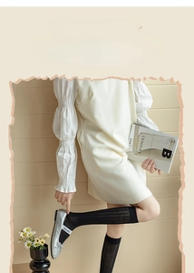 Close-up of black ribbed knee-high socks paired with silver Mary Jane shoes and soft decor