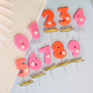 Candele di compleanno numeriche rosa e arancioni con stelle bianche e basi dorate 0-9