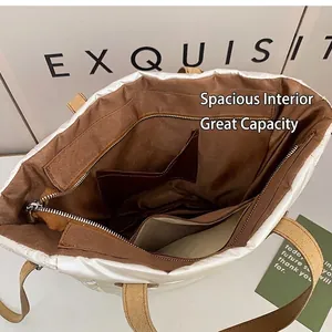 Borsa tote trapuntata bianca con ampio interno marrone e tasche portaoggetti multiple