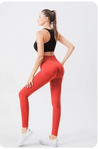Détail du legging de yoga rouge à taille haute porté avec une brassière de sport noire