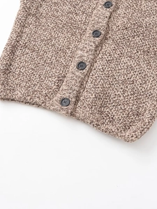 Close-up of chunky knit vest featuring brown melange yarn and four dark gray buttons