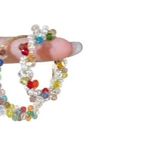Colorful beaded large hoop earrings with vibrant translucent beads on a gold metal frame
