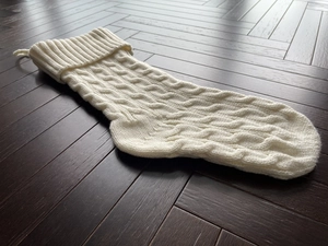 Close-up of white cable knit Christmas stocking detail showing premium texture and hanging loop