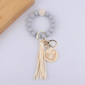 Grey silicone beaded bracelet keychain with beige tassel and round mama wooden charm