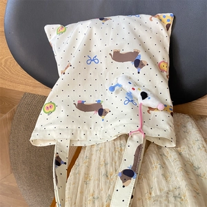 Close-up of canvas tote bag with dachshund print, black polka dots and plush dog charm