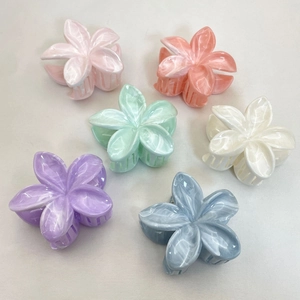 Flat lay of colorful flower hair claws in pink, orange, mint, white, purple and blue tones