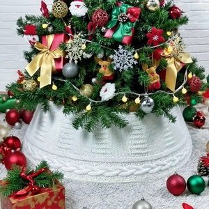Détails de la texture tricotée d'un cache-pied de sapin de Noël blanc à torsades