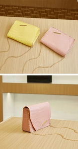 Detail of pink and yellow crocodile pattern crossbody bags with gold chain straps
