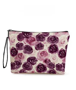 Detail view of purple rose pattern on canvas makeup bag with zipper and hand strap