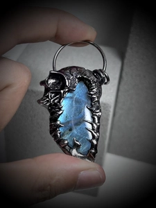Detail of vintage skull pendant featuring labradorite stone in silver metal frame