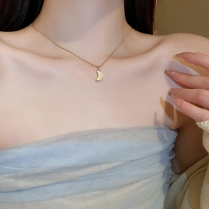 Collier lune doré élégant avec incrustation en nacre blanche porté au cou du mannequin