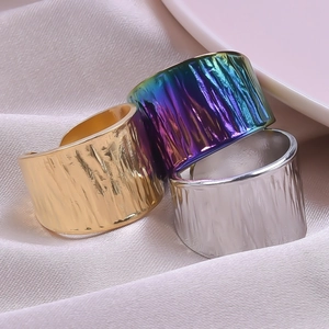 Macro shot of wide band stainless steel rings with wood grain texture in three colors