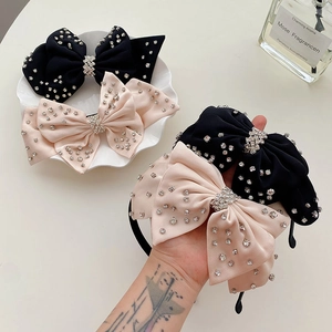 Detalle de elegantes diademas con lazo y pedrería en colores negro y rosa.