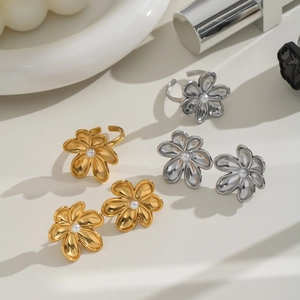 Detailed set of gold and silver camellia earrings and rings with central pearl accents