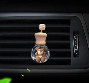 Close-up of cute brown bear cartoon car air freshener bottle on a vent mount