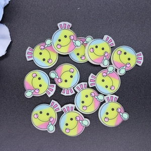 Macro detail of colorful resin candy charms with smiley face and thumb-up glitter designs