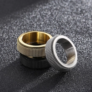 Detailed trio of rotatable stainless steel rings with industrial mesh texture in gold silver black