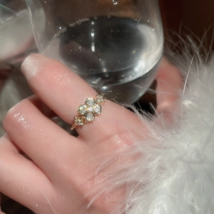 Detailed view of elegant gold zircon flower ring with sparkling stones on a model hand