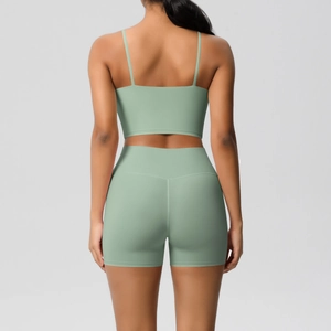 Detail view of mint green high-waisted yoga shorts and cross-back sports bra set