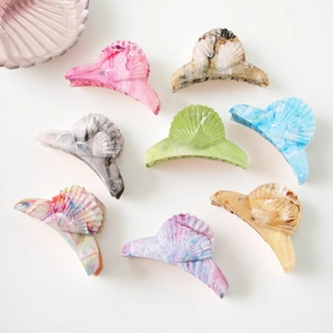 Eight large shell-shaped acetate hair claws in various marble colors on white backdrop
