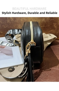 Close-up of black quilted shoulder bag featuring gold hardware and lettered strap