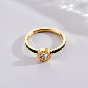Bague dorée avec chiffres romains, émail noir et un zircon étincelant au centre