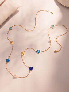 Nahaufnahme der Goldhalskette mit blauen Kristallblöcken, Perlen und Goldanhängern