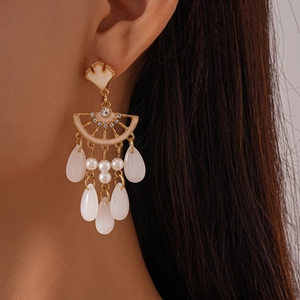 Gros plan de boucles d'oreilles feuille de ginkgo avec strass et perles blanches
