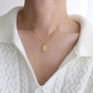Gros plan du pendentif rectangulaire doré avec croissant de lune et rayons de soleil