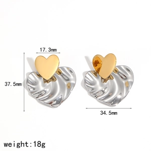 Détail de boucles d'oreilles cœur bicolores avec texture ondulée et largeur de 34,5 mm