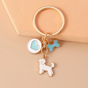Detail of dog keychain with heart and bone charms on a geometric pedestal