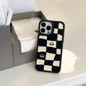 Detail of black and white checkerboard plush phone case with soft embroidered texture