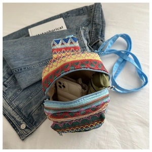 Ethnic style embroidered chest bag with colorful stripes showing storage capacity